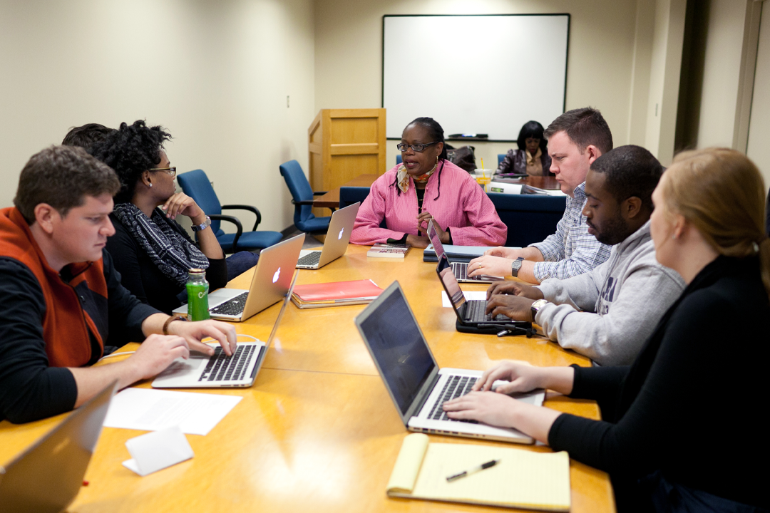Law classroom with students and professor at table together